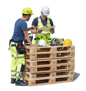 two construction workers discussing by the pile of pallets