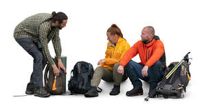 cut out group of hikers sitting and unpacking hiking gear