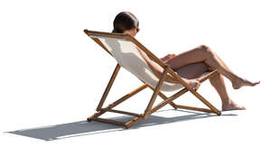 backlit woman sunbathing in beach chair