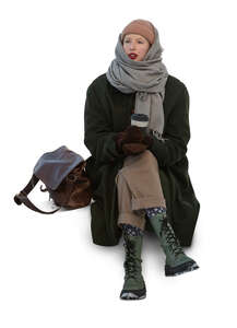 woman sitting outside in winter and drinking coffee