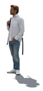 backlit man in white shirt and jeans standing