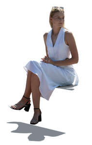 backlit lady in a  white dress sitting