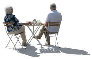 cut out backlit elderly couple sitting in a cafe