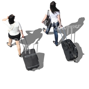 two women with suitcases walking