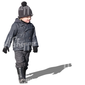 small boy in a black jacket walking