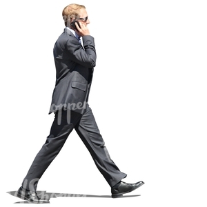 man in a suit walking and talking on the phone