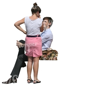 woman standing and talking to a sitting man