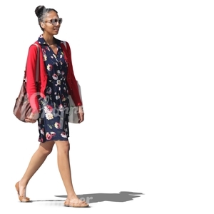 black woman in a blue dress walking and smiling