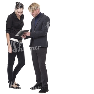 man and a woman standing and looking at the ipad