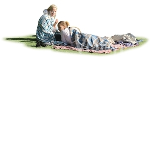 two women wrapped in blankets sitting on the grass