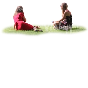 two women sitting together on the grass