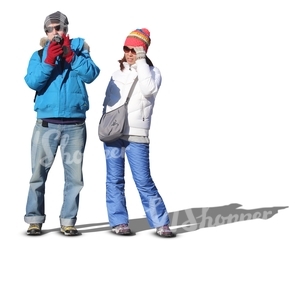 man and woman in winter clothes standing and taking pictures