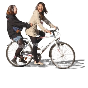 two laughing asian girls riding a bicycle