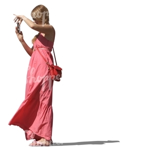 woman in a pink dress taking a picture