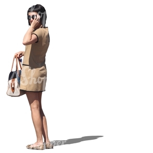 woman in a beige dress standing and looking at smth