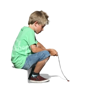 A young boy sitting on the sidewalk