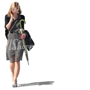 woman with an umbrella in her hand walking and talking on the phone