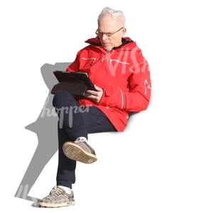 elderly man sitting and reading a tablet