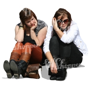 Two girls sitting on the sidewalk