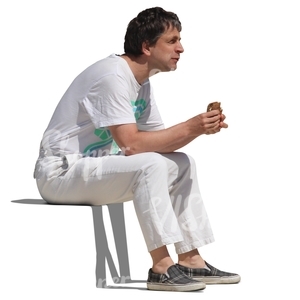 man in white clothes sitting and eating