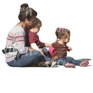 woman with two children sitting on the ground