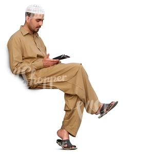 arab man sitting and looking at his phone