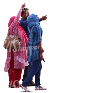 man and two hindu women standing and looking at smth