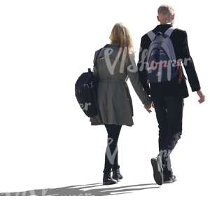 backlit couple walking hand in hand