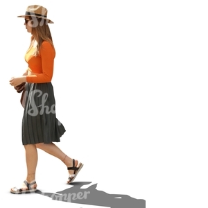 backlit woman with a hat walking