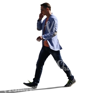 backlit young man walking hastily while talking on the phone