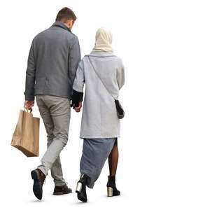 man and woman in a grey coats walking hand in hand