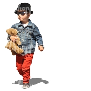 boy walking with a teddy bear under his arm