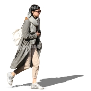 woman in a grey overcoat walking on a sunny day