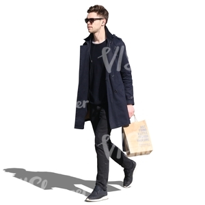 man wearing a black jacket walking with a shopping bag