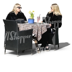 two blonde women sitting in a street cafe and talking