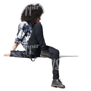 man with curly hair sitting on a balustrade