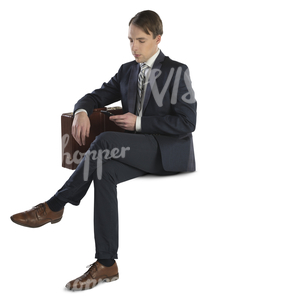 businessman with briefcase sitting and looking at his phone