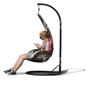 woman sitting in a hanging chair and looking at her phone