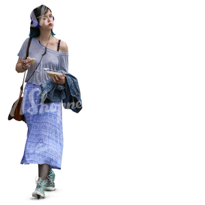 young woman with headphones walking and eating a sandwich 