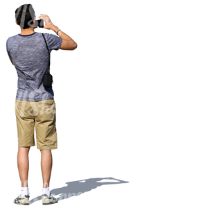 man in shorts standing and taking a picture