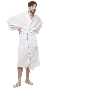 man in a white bathrobe standing in a spa