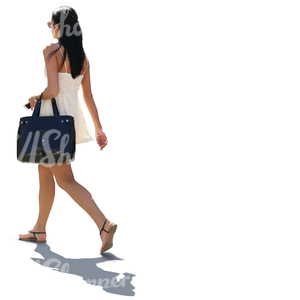 backlit woman in a white summer dress walking in the street