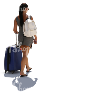 backlit woman in a summer dress walking with a big suitcase