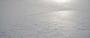 large field of icy snow in sunlight