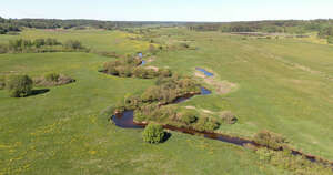 aerial view of a creek between grasslands