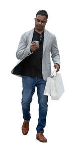 indian man with shopping bags and a phone walking