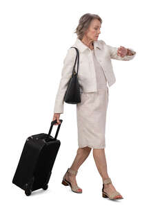 cut out grey haired older woman with a travel suitcase walking