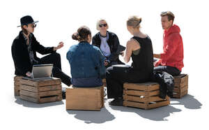 cut out backlit group of young people sitting on wooden boxes