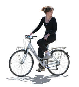 backlit woman riding a bike and looking back over her shoulder