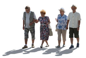 two backlit elderly couples walking